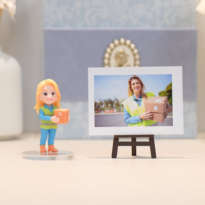 Figurine of a woman holding a box next to a framed photo of a woman with a box outdoors.